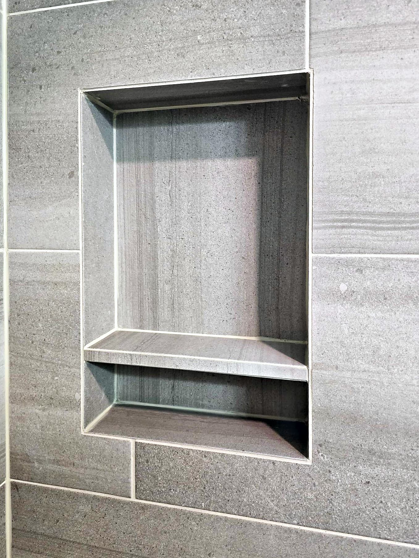Recessed tile shower niche with a tile shelf and mitered edges in Ambler