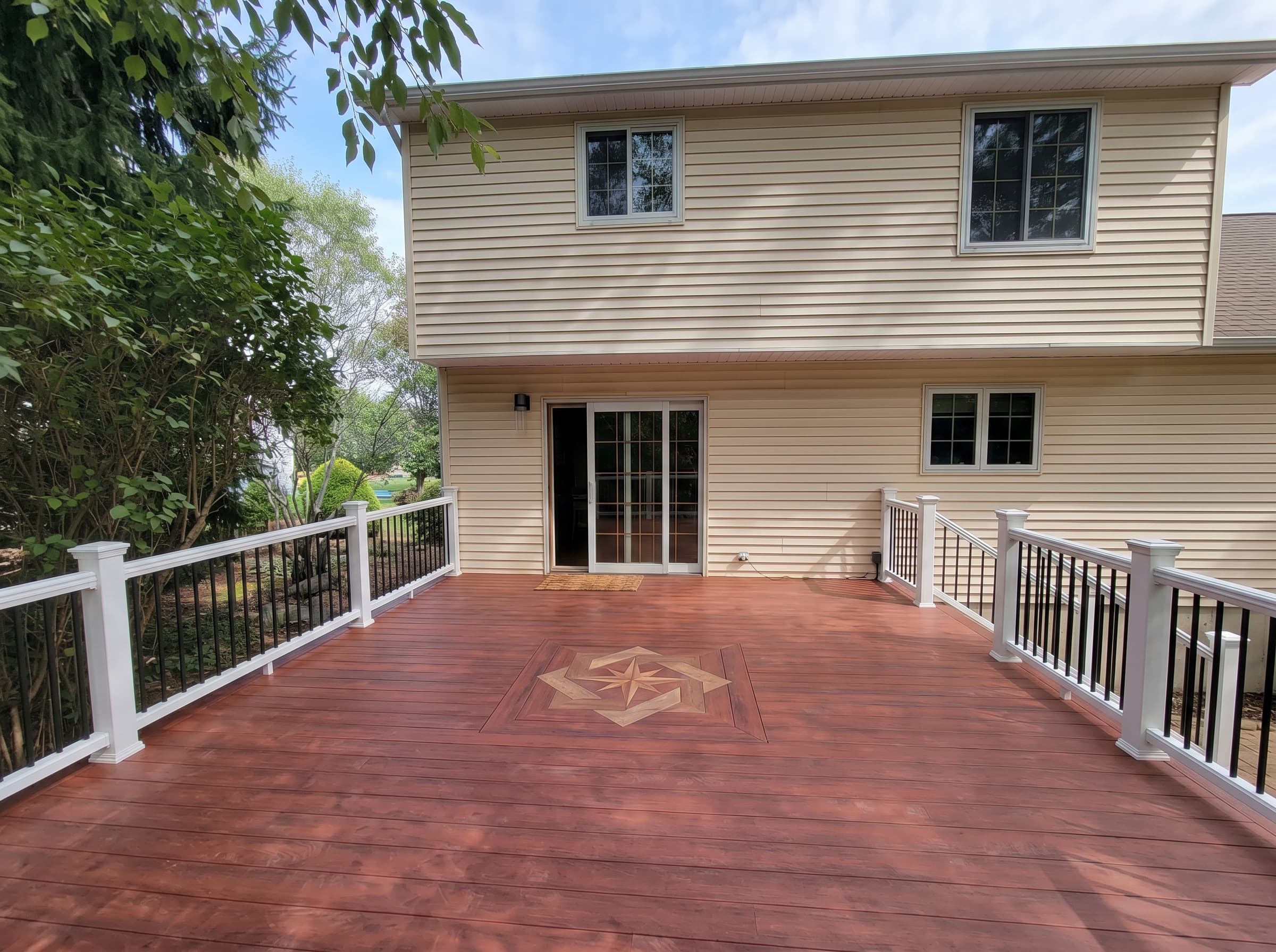Rebuilt raised deck with white railing and stone skirt in New Hope