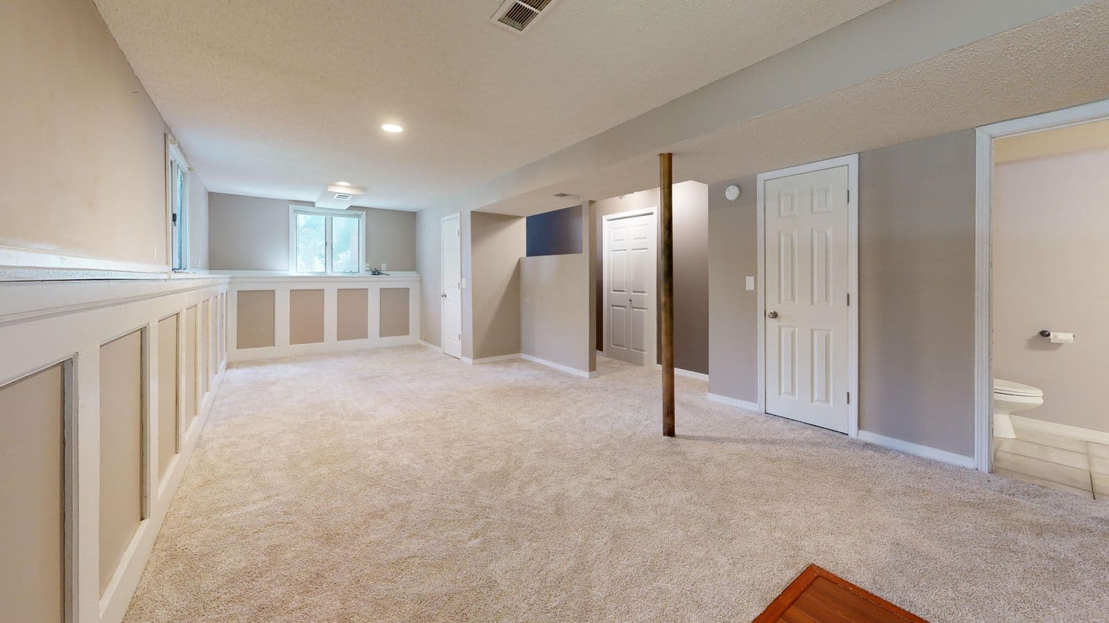 Finished basement with carpet, wainscoting, and recessed lighting